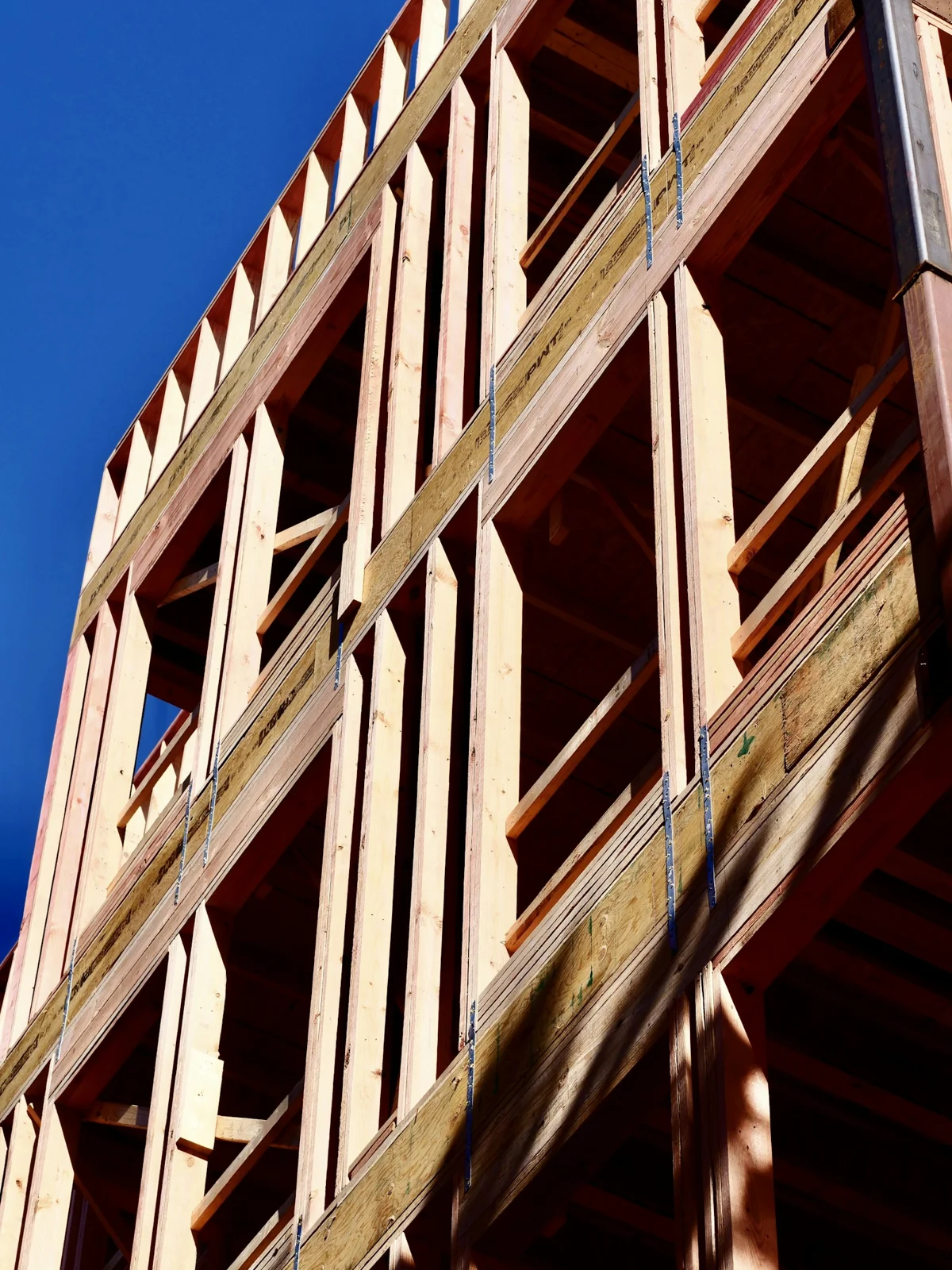 Exposed timber framing, headers, and metal connections on a new building
