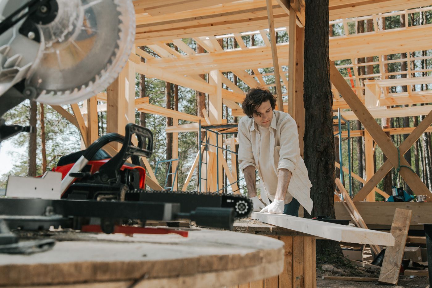 Carpenter preparing a timber board inside a building under construction