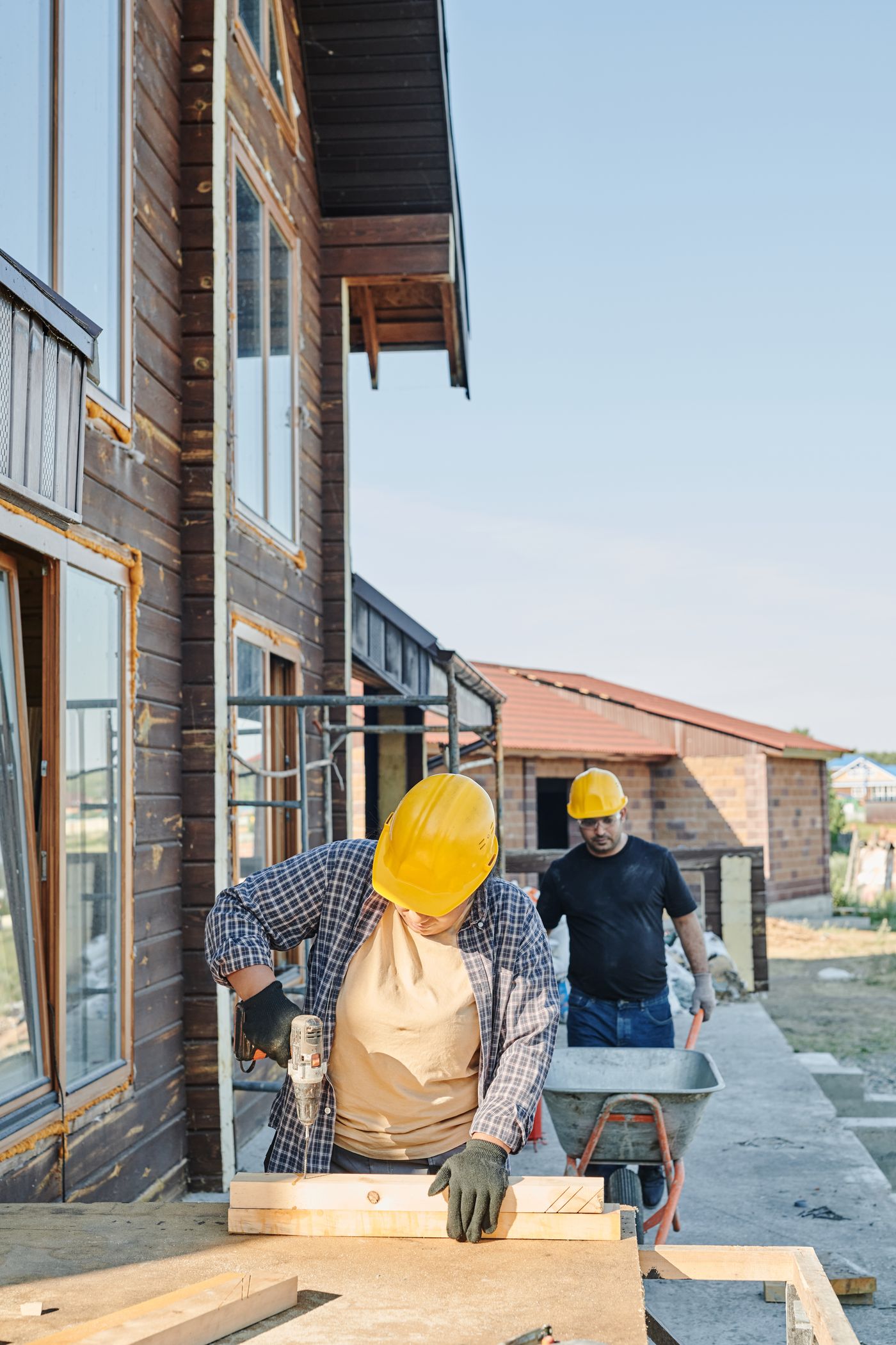 Crew members cutting timber and moving materials during a house renovation