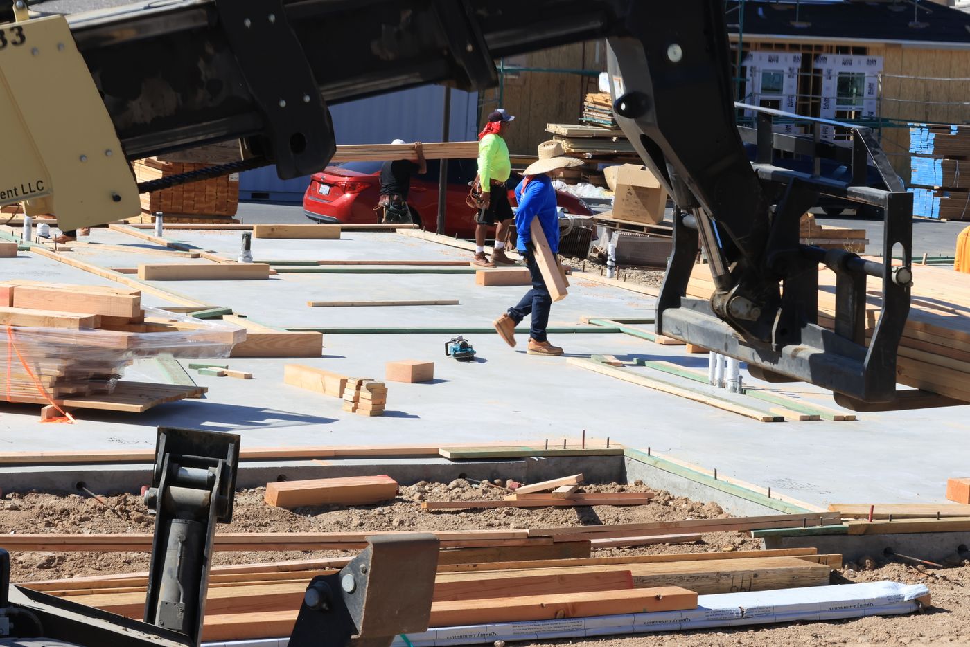 Construction crew moving timber across a residential jobsite